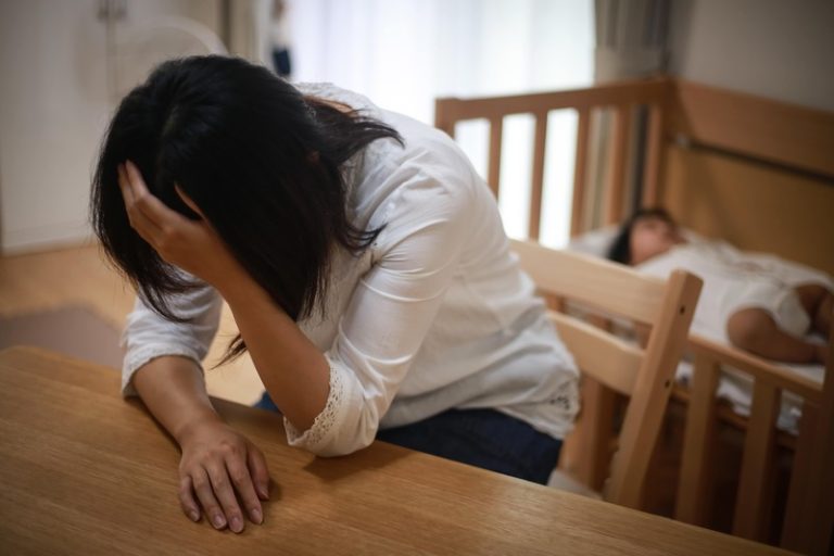 Une jeune maman épuisée par la dépression post-partum, venant de coucher son enfant.