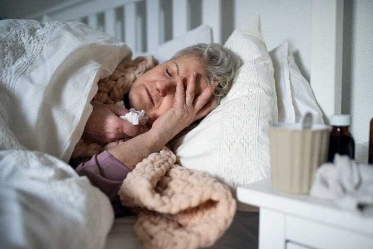Une grand-mère est malade, emmitouflée dans son lit.