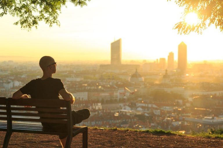 Un homme sur un banc à la basilique de fourvière, se détendant et profitant du lever du soleil d'été Lyon.