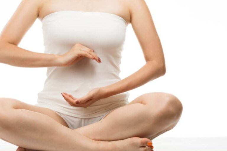 Une femme fait une position de yoga pour améliorer son transit intestinal.