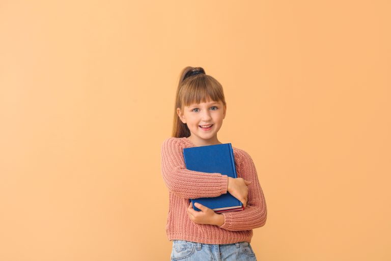 Un enfant en bonne santé tenant dans ses bras un carnet.