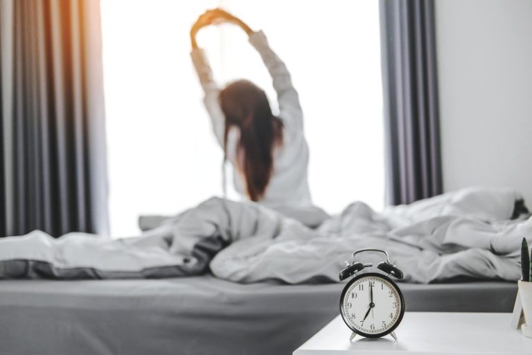 Une femme qui vient de se réveiller après une bonne nuit de sommeil.