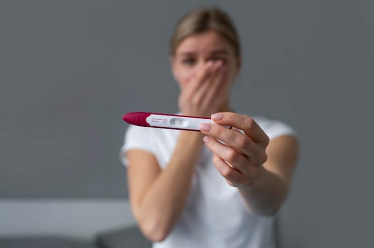 Une femme triste de constater que son test de grossesse est positif.