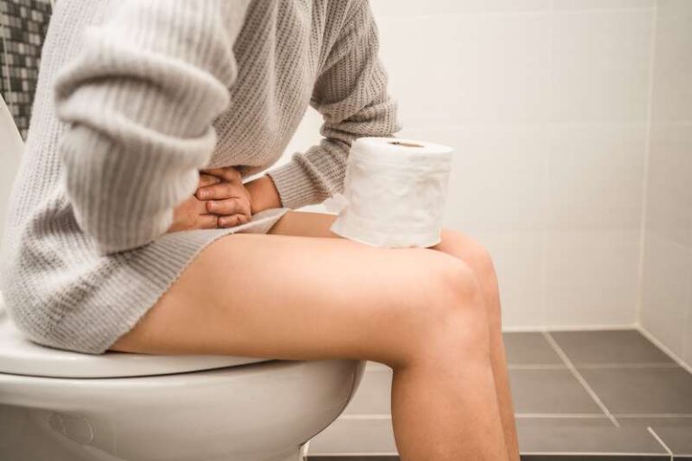 Une femme qui souffre d'une infection urinaire essayant d'uriner.