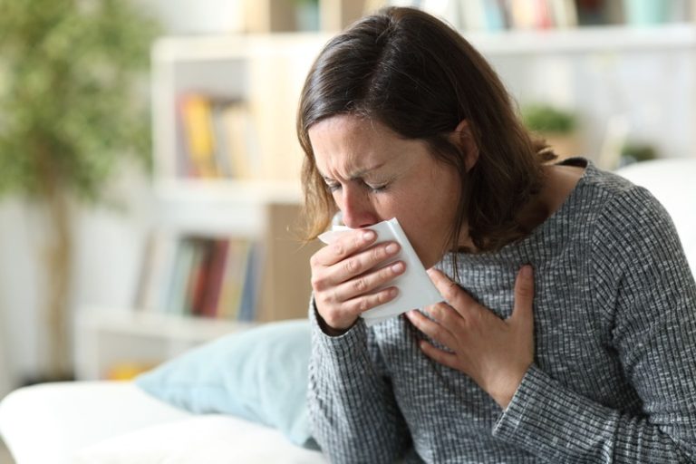Une femme qui tousse beaucoup à cause d'une pneumonie.