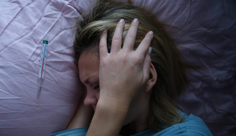 Une femme atteinte d'une méningite avec un pic de fièvre dans son lit.