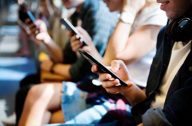 Des adolescents rivés sur le téléphone qui regardent les nouvelles tendances TikTok.