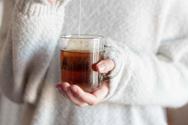 Une femme qui boit son thé comme à son habitude.