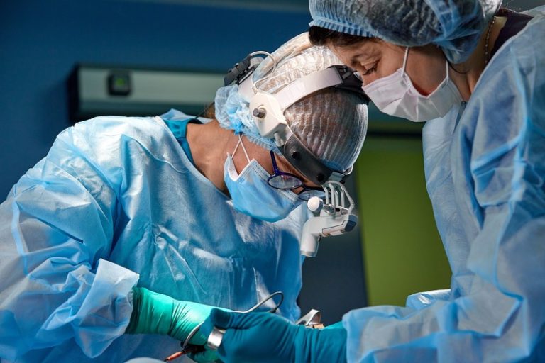 Des chirurgiens en train d'opérer une femme pour lui poser une bioprothèse mammaire.
