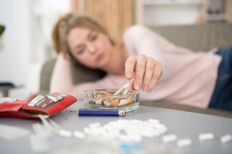 Une femme qui fume du CBD en prenant son traitement médial.