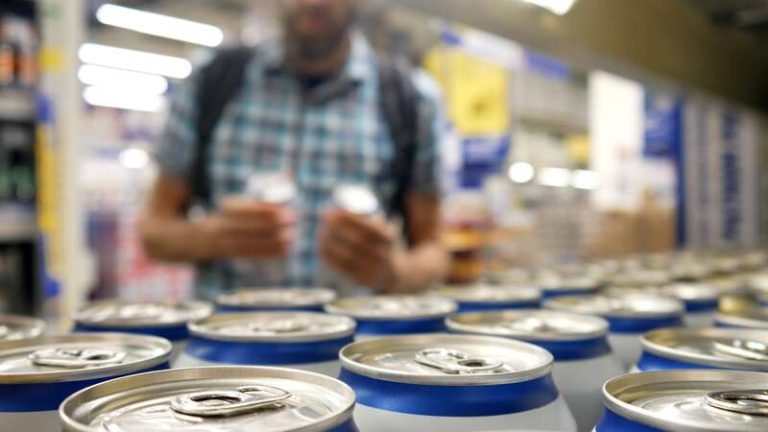 Un jeune homme qui achète ses boissons énergisantes en grande surface.