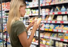 Manger sainement commence par comprendre les étiquettes Une femme examine une étiquette alimentaire pour être en meilleure santé