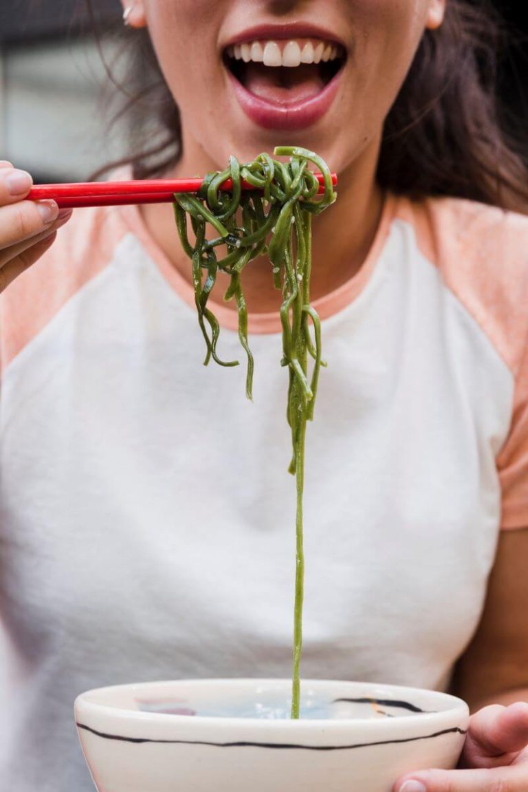 Une femme entrain de manger des algues, qui sont très bonnes pour la santé