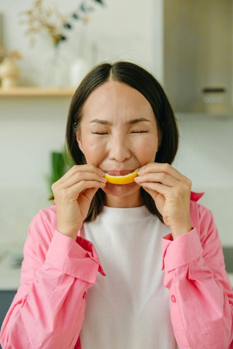 Femme en train de manger un fruit qui lui provoque des picotements.
