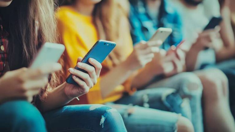 Des jeunes atteints de nomophobie, les yeux rivés sur leurs écrans de téléphone.