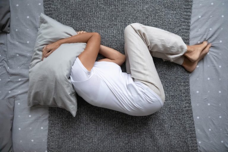 Une femme allongée dans son lit souffrant de troubles du sommeil, signe annonciateur d'Alzheimer.