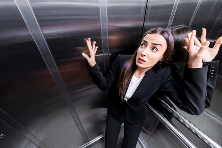 Une jeune femme souffrant de claustrophobie dans un ascenseur.