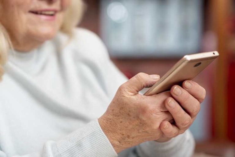 Une personne âgée qui utilise son smartphone pour freiner leur déclin cognitif.