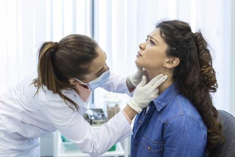 Une femme, à la gorge gonflée, qui a un ganglion.