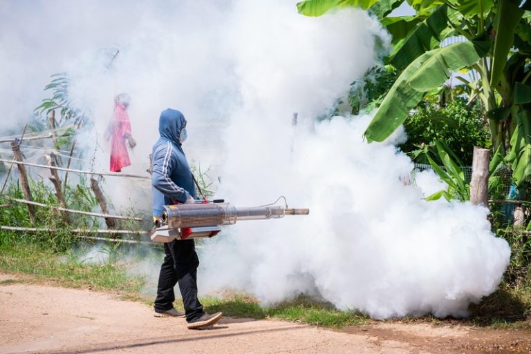 Un homme qui pulvérise de l'insecticide pour éradiquer le paludisme.