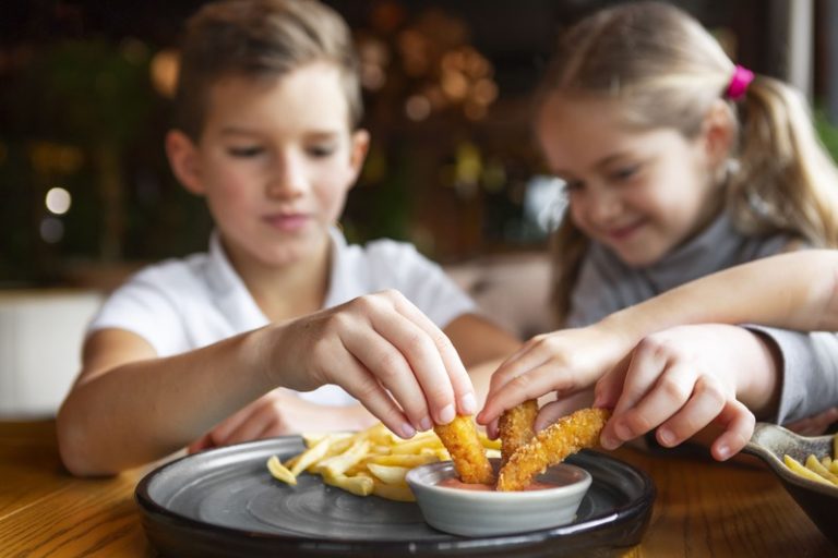 Des enfants en train de manger des produits ultra-transformés.