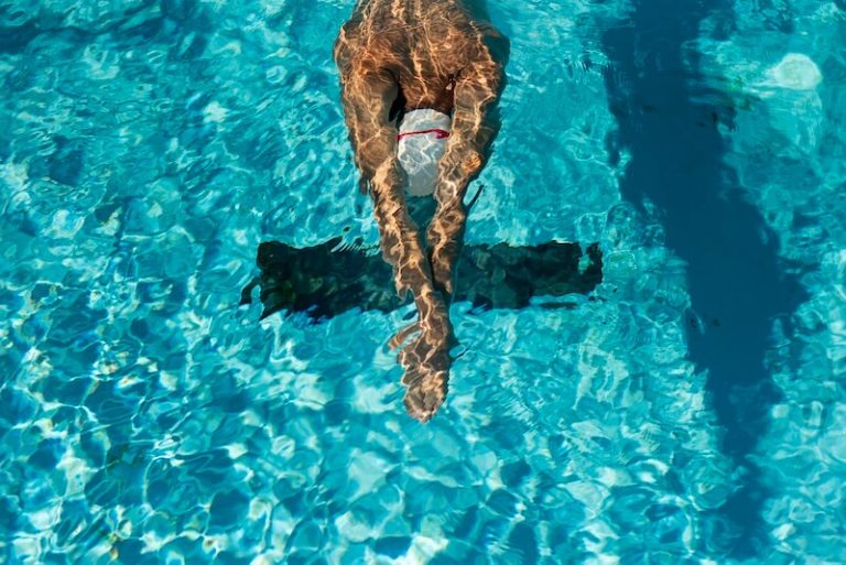 Nageur qui fait une coulée sous l'eau dans une piscine.