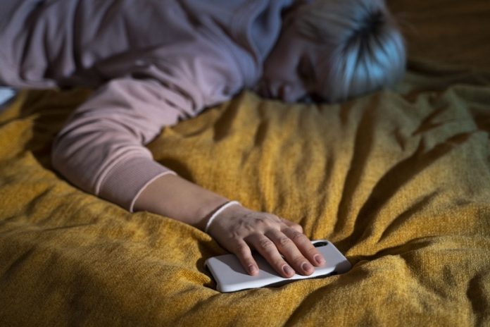 s'endormir avec du son ce que ca révèle sur notre personnalité Ma Santé Une femme qui s'endort avec du son sur son téléphone.