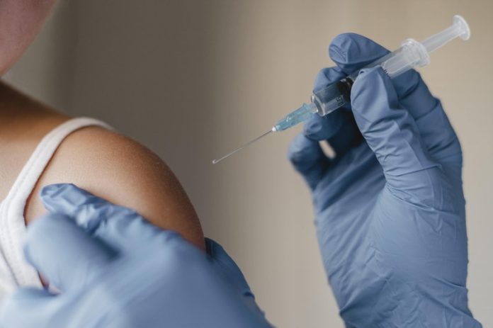 Un adolescent qui se fait vacciner contre le HPV.