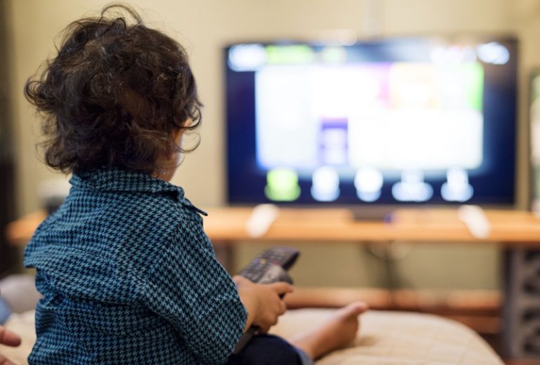 Un enfant de moins de 3 ans scotché devant l'écran avec la télécommande à la main.