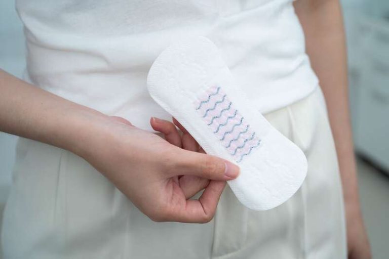 Une femme qui utilise la serviette hygiénique intelligente pour détecter une potentielle maladie grave.