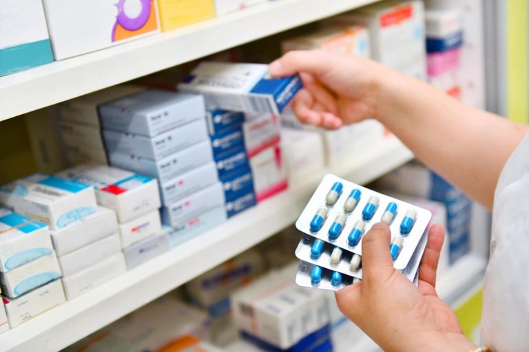 Une pharmacienne qui tient dans ses mains les nouvelles plaquettes réduites de benzodiazépines.