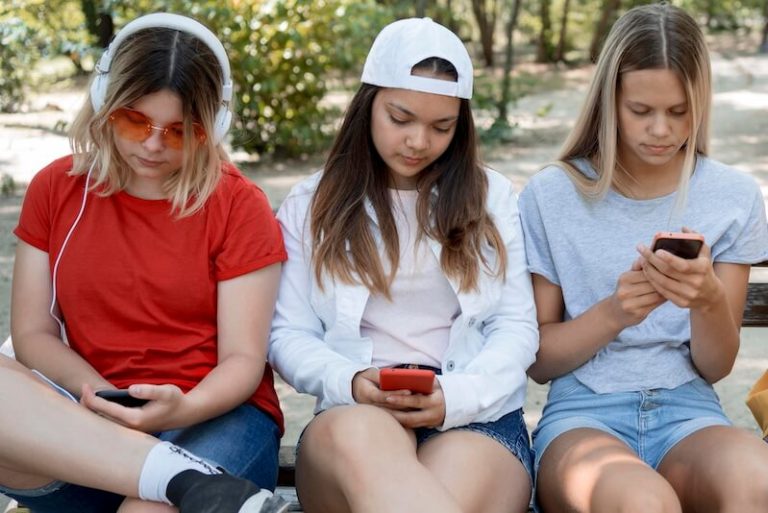 Un groupe de jeunes filles avec leurs smartphones.