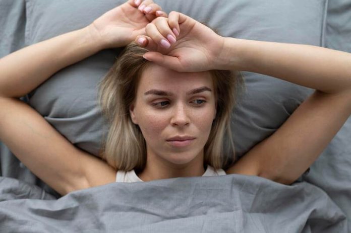 Une femme qui ne trouve pas le sommeil et reste éveillée dans son lit