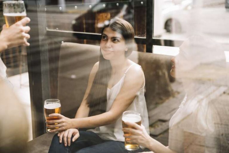 Une femme qui boit une bière alors qu'elle a du cholestérol.