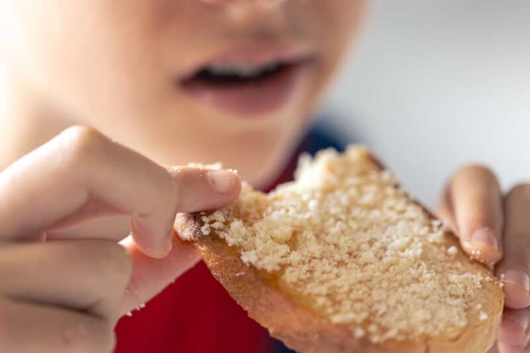Un enfant allergique au gluten qui mange du pain sans gluten.