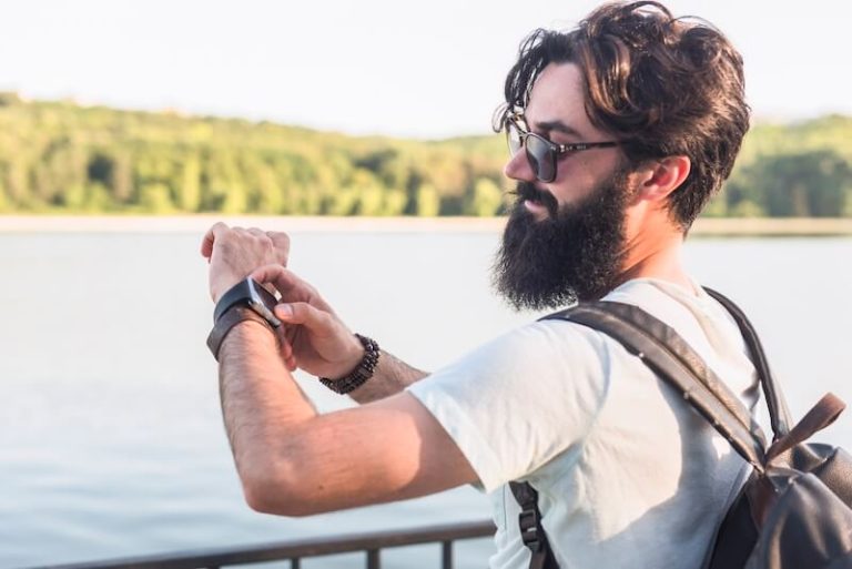 Un homme regarde sa montre pour savoir si c'esr le bon moment de se baigner.