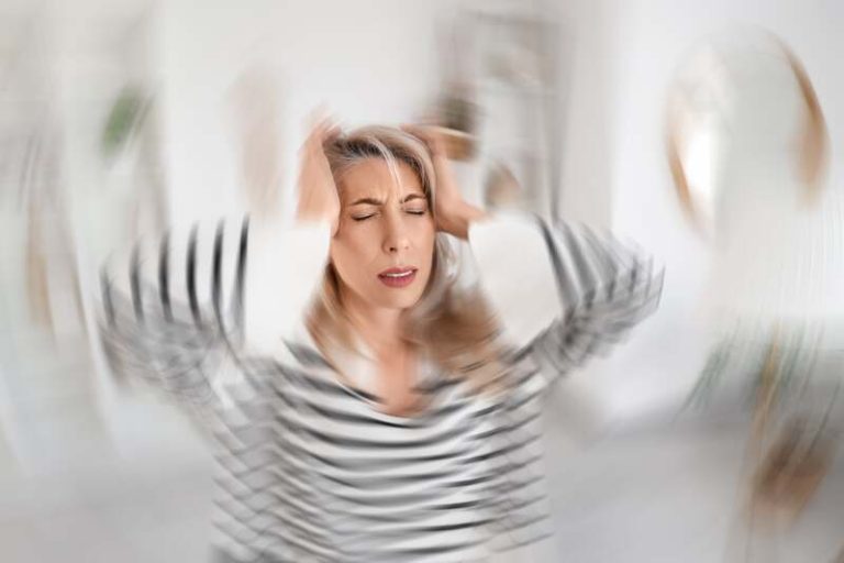 Une femme qui se tient la tête de fatigue.
