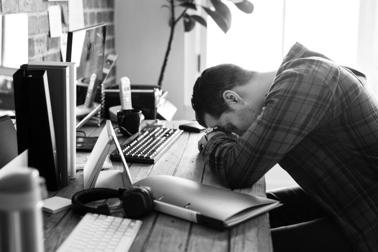 Un patron épuisé, au bord du gouffre, à son bureau.