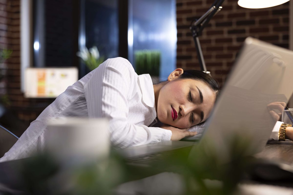 Une femme qui fait la sieste au travail pendant sa pause déjeuner.