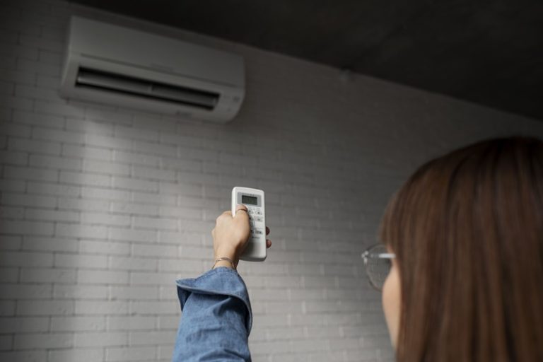 Une femme qui allume son climatiseur pendant la canicule.