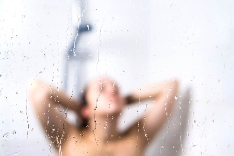 Une femme en tain de faire pipi sous la douche.