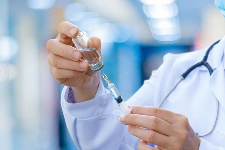 Un médecin avec un vaccin contre la grippe dans les mains.