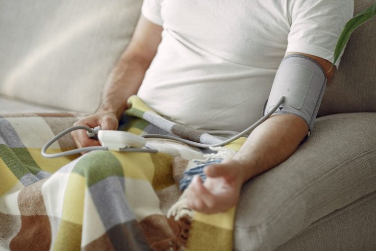 Un homme qui prend sa tension pour suivre son hypertension artérielle.