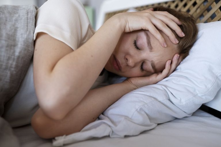 Une femme atteinte de encéphalomyélite myalgique/syndrome de fatigue chronique épuisée dans son lit.