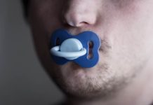 Un homme adulte qui utilise une tétine pour réduire son stress.