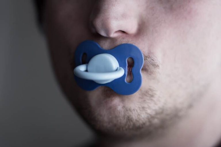 Un homme adulte qui utilise une tétine pour réduire son stress.