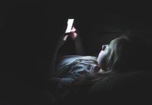 Une jeune adoslescente interné en hôpital psychiatrique qui regarde son téléphone.