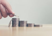 Une main qui représente les mutuelles et des tas de pièces qui symbolisent l’augmentation des complémentaires santé.