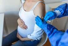 Une femme enceinte qui fait la double vaccination grippe et Covid-19.