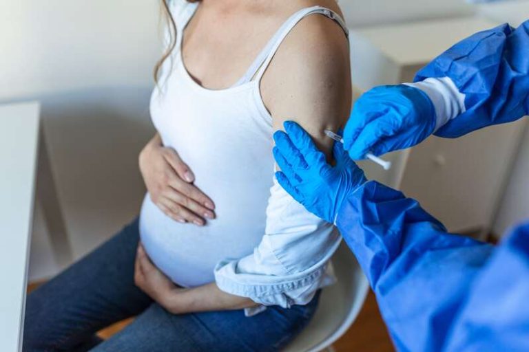 Une femme enceinte qui fait la double vaccination grippe et Covid-19.